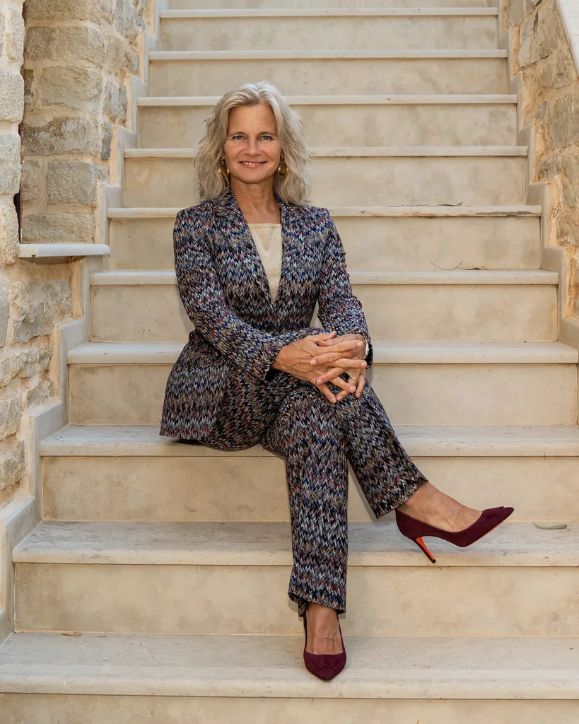 Dawn Daniel, MD, FAASM, FMCP-M, seated on stone stairs